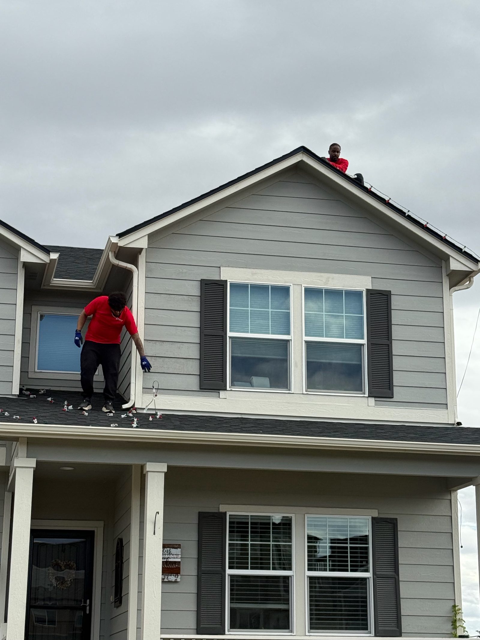 Professional Christmas light installation crew on roof installing LED lights on the Colorado Front Range Professional Christmas light installation crew on roof installing LED lights on the Colorado Front Range