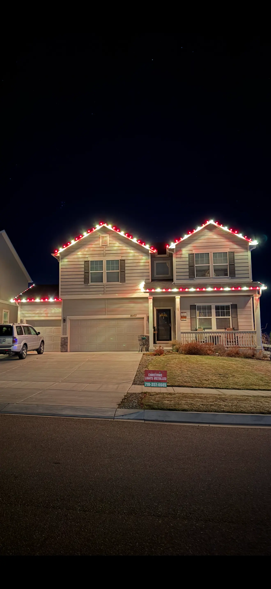 Red and white LED roofline on a two-story home — Front Range portfolio example